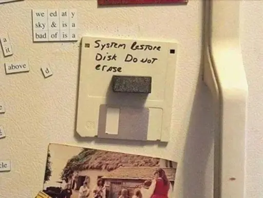 Picture of a floppy disk attached to a fridge door with a magnet labeled: "System restore disk do not erase"